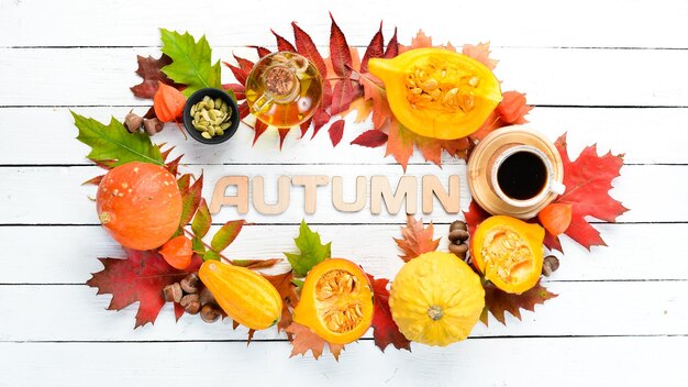 Fondo de otoño con hojas de otoño de calabaza de café sobre un fondo de madera blanca Vista superior Espacio libre para su texto