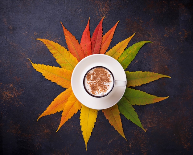 Fondo del otoño con las hojas y la taza de café.