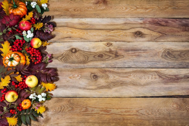 Fondo de otoño con rowan y hojas de roble, calabazas, manzanas, espacio de copia