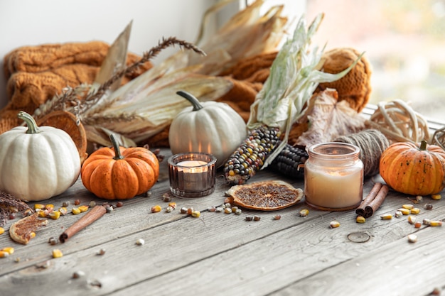 Fondo de otoño con velas calabazas maíz y elemento de punto