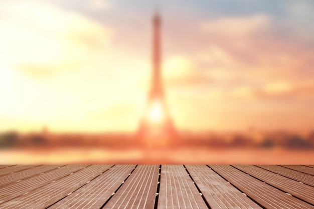 Fondo. Paisaje borroso de la torre eiffel con terraza de madera