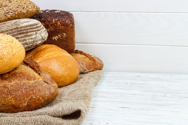 Fondo de panadería, surtido de pan. Vista superior de bollos de centeno y baguettes francesas