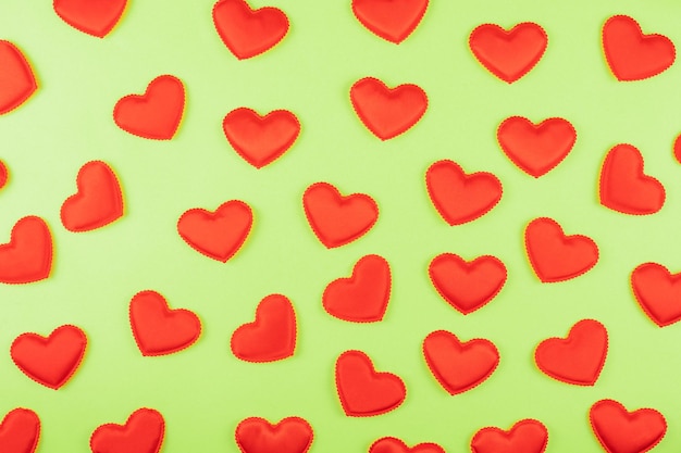 Fondo de papel verde del día de san valentín con fondo de corazones rojos día de san valentín o concepto de amor