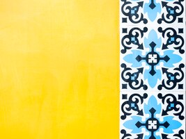 Foto fondo de pared amarilla con azulejos de mosaico de patrón azul estilo marroquí con espacio de copia. fondo de azulejos de cerámica portuguesa tradicional vintage.