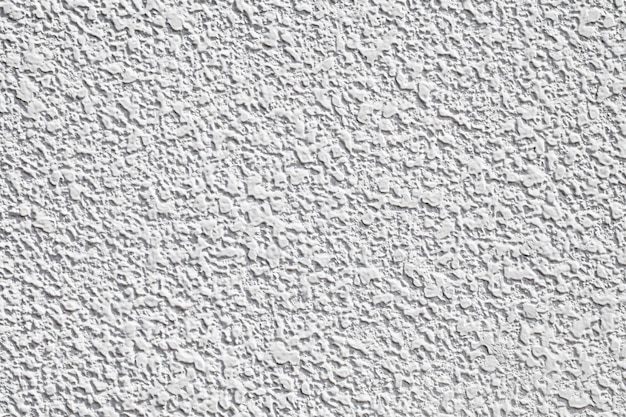 El fondo de la pared es de yeso blanco con gotas de textura uniforme de mortero blanco