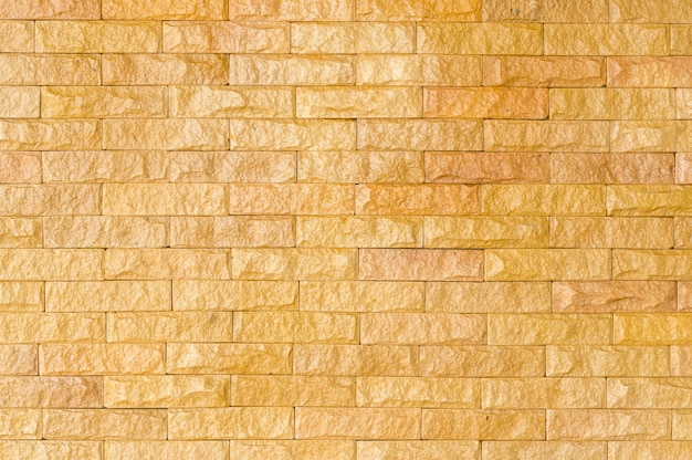 Fondo de pared de ladrillo dorado brillante o piedra amarilla de textura utilizada para decorar la casa o el edificio