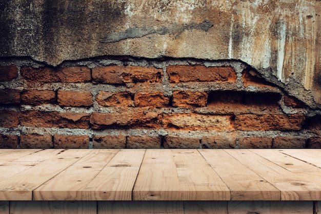 Foto fondo de la pared de ladrillo y montaje de exhibición de tabla de madera vacía para el producto con el espacio de la copia.