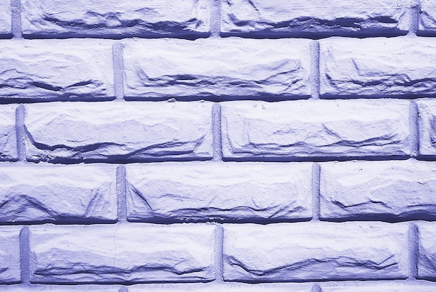 Foto fondo de pared de ladrillos apilados en fila teñidos en color de moda de 2022 por muy peri