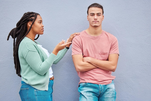 Fondo de pared de pareja interracial y argumento en el metro con mujer negra pregunta y conversación Pareja joven de la generación z y conflicto en la ciudad con pelea de relaciones y brazos enojados cruzados