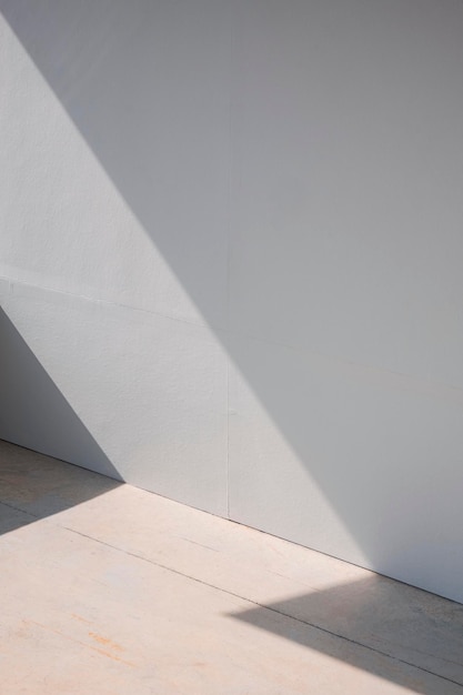 Fondo de pared de tablero de yeso gris en blanco y piso de concreto con luz y sombra en la superficie