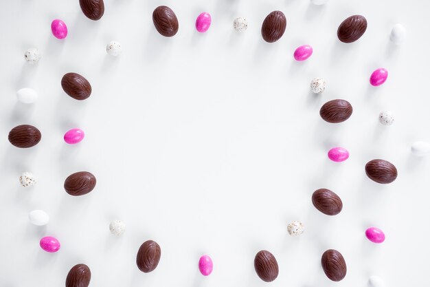 Fondo de Pascua - cerrar el marco del círculo por huevos y dulces sobre fondo blanco.