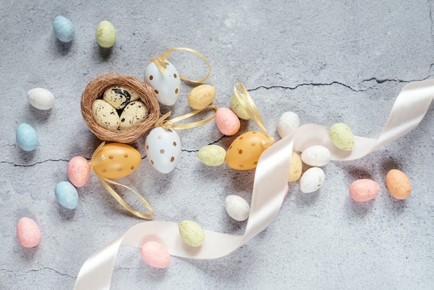 Fondo de Pascua con coloridos huevos de Pascua con nido de pájaro y cinta de raso rosa con espacio de copia