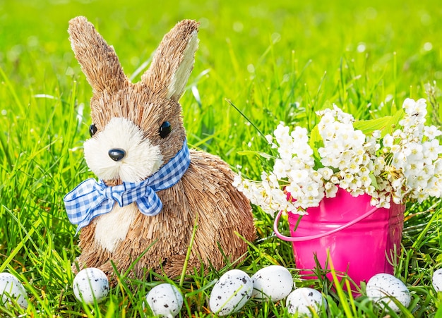 Fondo de Pascua con conejo, huevos, hierba verde y flores.