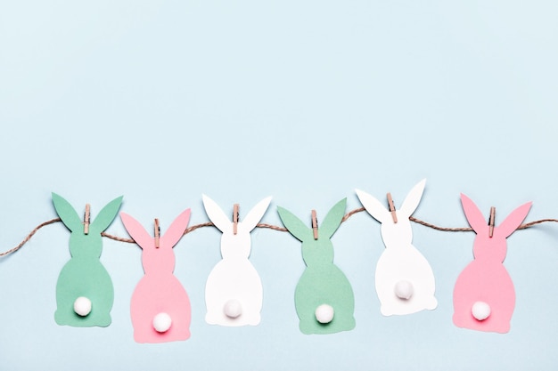 Foto fondo de pascua con conejos de papel diy, guirnaldas y dulces huevos de pascua