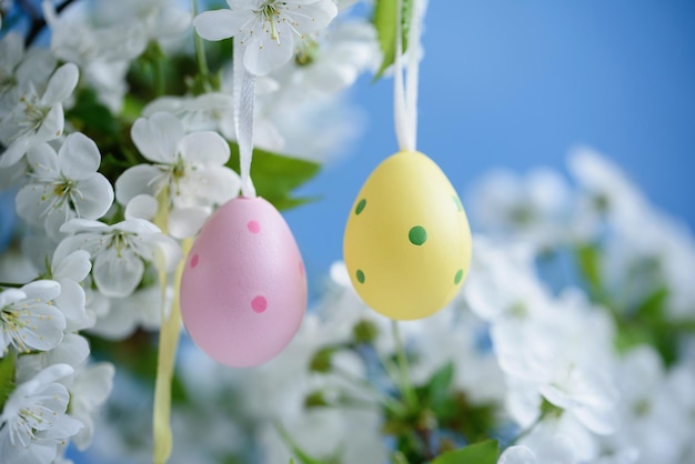 Fondo de Pascua Feliz concepto de vacaciones de Pascua con lindos huevos coloridos y flores sobre fondo azul