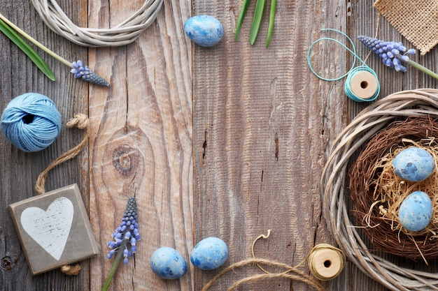 Fondo de Pascua con huevos, flores de jacinto azul y corazón de madera