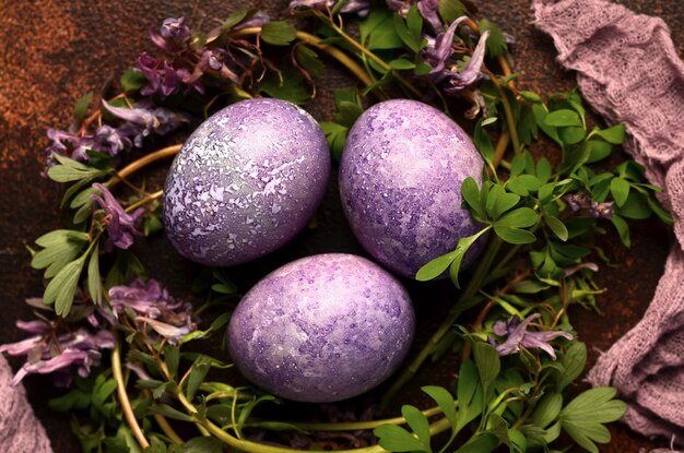 Fondo de Pascua con huevos y flores púrpuras