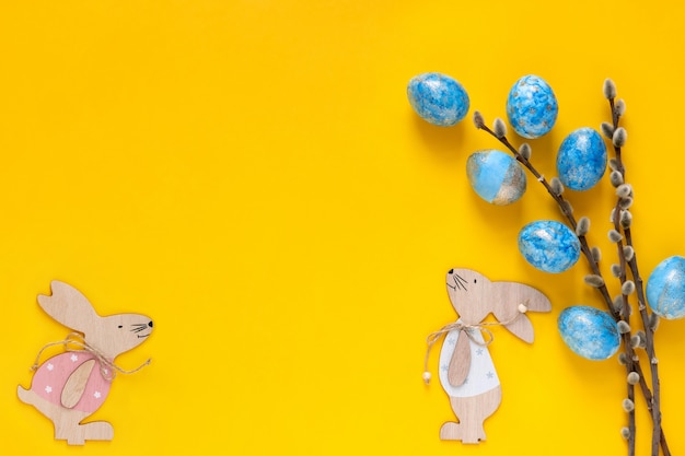 Fondo de Pascua con huevos de Pascua azul y conejito de Pascua. Vista superior con espacio para su texto.