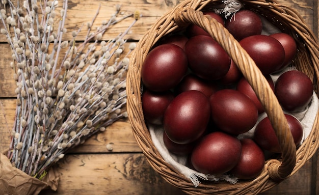 Fondo de Pascua con huevos de Pascua en una canasta sobre un fondo de madera decorado con ramitas de withy Vista superior con espacio de copia Pascua ortodoxa Lay Flat Estilo natural Huevos de Pascua rusos tradicionales