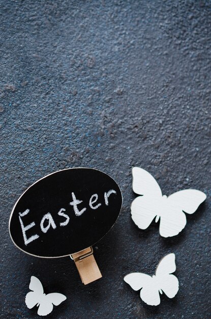 Fondo de Pascua con las mariposas de madera decorativas y la inscripción de Pascua.