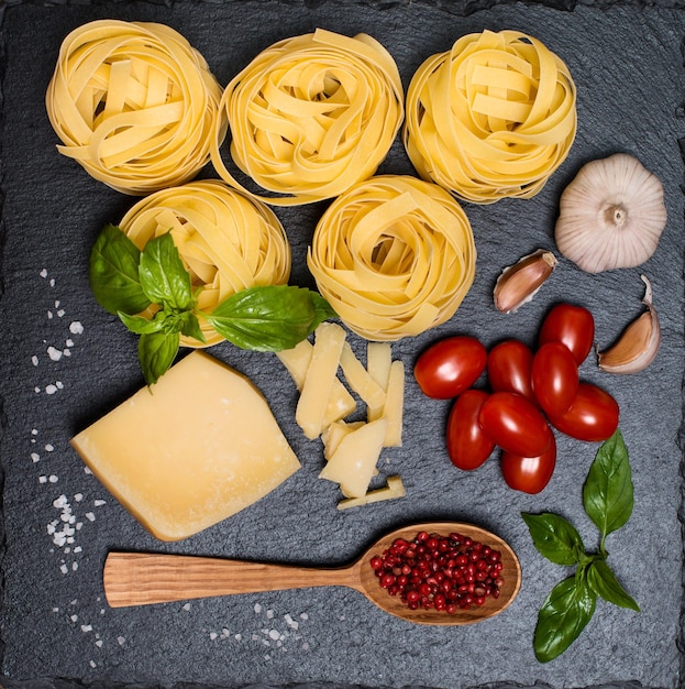 Fondo de pasta con ingredientes para cocinar en la vista superior del tablero de pizarra