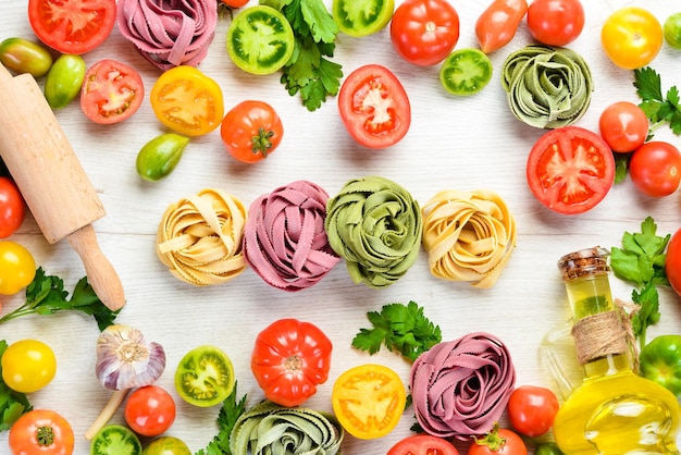 Fondo de pasta tagliatelle de pasta seca e ingredientes sobre un fondo blanco Vista superior Espacio libre para el texto