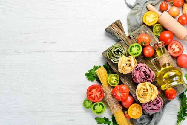 Fondo de pasta tagliatelle de pasta seca e ingredientes sobre un fondo blanco Vista superior Espacio libre para el texto