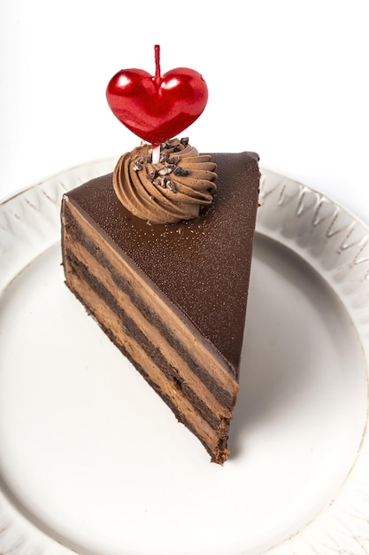 Fondo de pastel de chocolate con vela de corazón para el Día de San Valentín