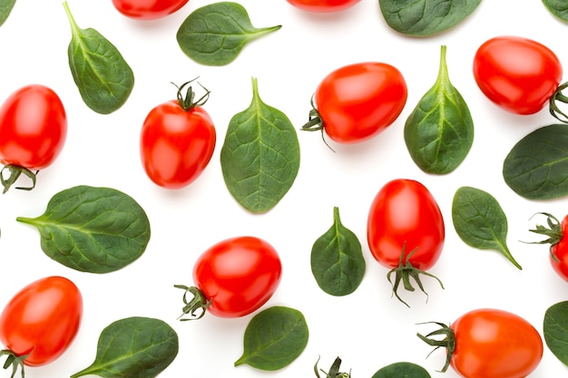 Fondo de patrón de espinacas y tomates en blanco. Vista superior