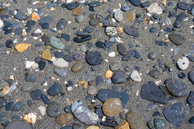 Fondo de pequeñas piedras junto a la playa.