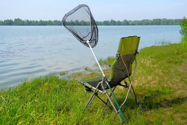 Fondo de pesca Sillón y red de pesca en el lago Estilo de vida