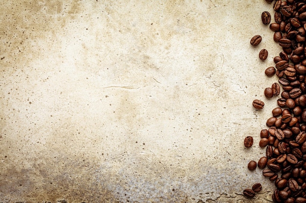 Fondo de piedra clara grunge con granos de café textura de mesa de hormigón rayado con granos tostados