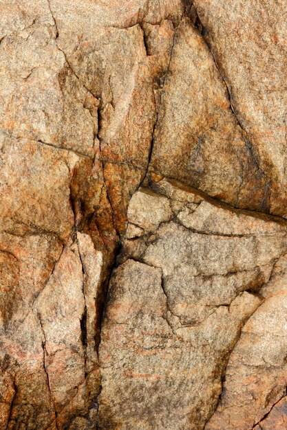 Fondo de piedra o roca marrón Detalle de la naturaleza de las rocas Primer plano de una pared de piedra marrón áspera