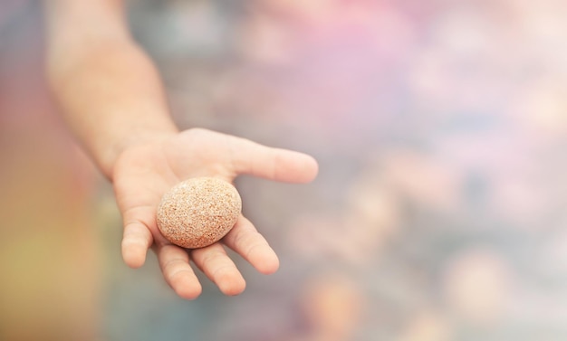 fondo con una piedra redonda en la palma de un niño