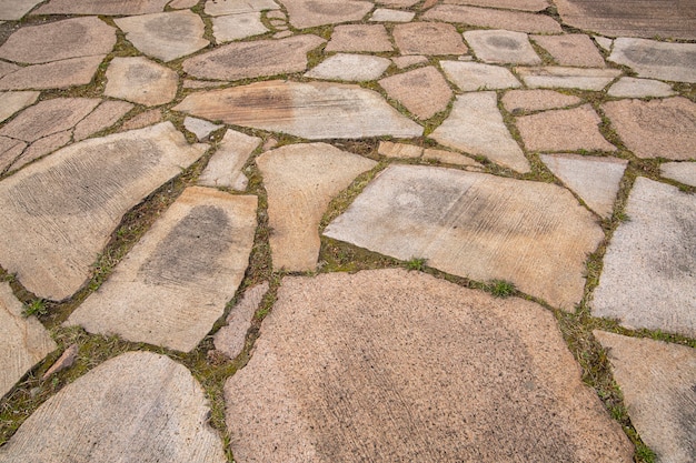 Fondo de piedras y pasto entre ellos. Textura de piedra