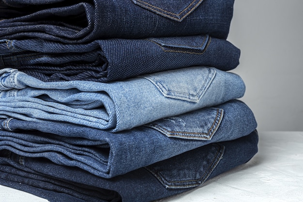 Fondo de la pila de ropa de los pantalones de los tejanos. Detalle de bonitos jeans azules