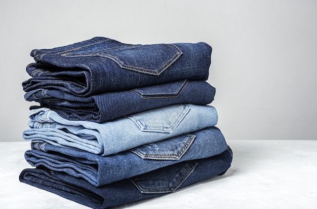 Fondo de la pila de ropa de los pantalones de los tejanos. Detalle de bonitos jeans azules