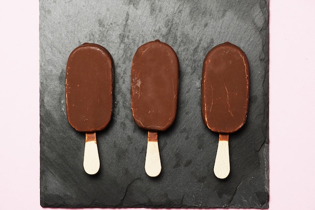 Fondo de pizarra oscura de helado de chocolate. endecha plana. diseño plano. comida gastronómica