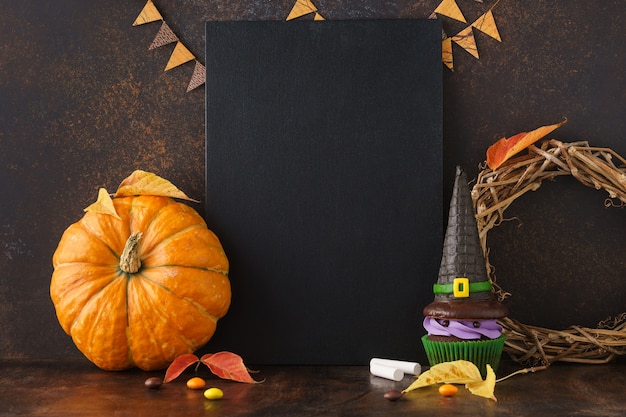 Fondo de pizarra de otoño con calabaza y golosinas de Halloween