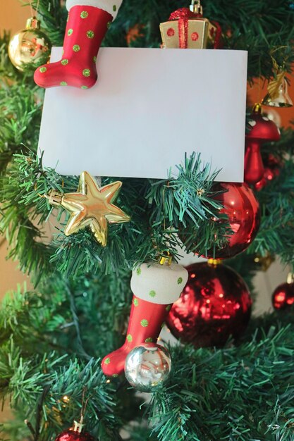 Fondo de plantilla de Navidad con tarjeta de felicitación blanca en blanco para carta de invitación o marketing por correo electrónico entrante. Rodeado de decoraciones navideñas.