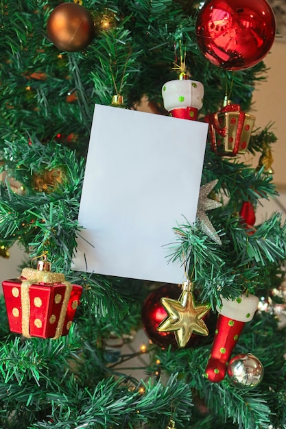 Fondo de plantilla de Navidad con tarjeta de felicitación blanca en blanco para carta de invitación o marketing por correo electrónico entrante. Rodeado de decoraciones navideñas.