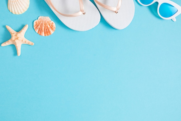 Fondo de playa con accesorios sobre fondo azul.