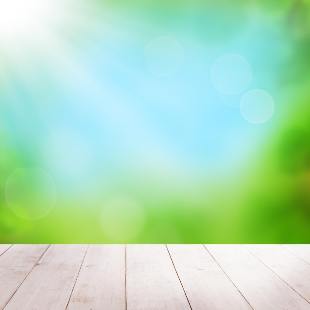 Foto fondo de primavera con cielo azul bokeh luz y mesa de madera vacía blanca fondo de salud verde