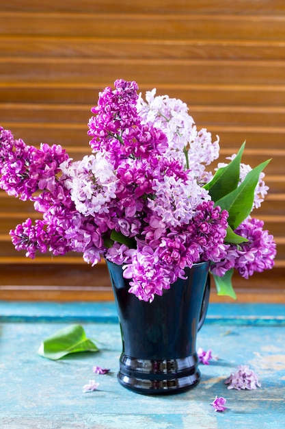 Fondo de primavera. Hermoso ramo lila fresco de flores púrpuras en el vaso.