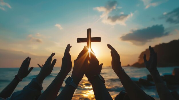 En el fondo de una puesta de sol un grupo de manos está orando y sosteniendo una cruz cristiana La silueta muestra manos sosteniendo la cruz mientras adoran a Dios