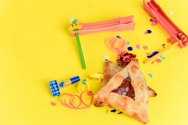 Fondo de Purim con traje de fiesta y galletas hamantaschen.