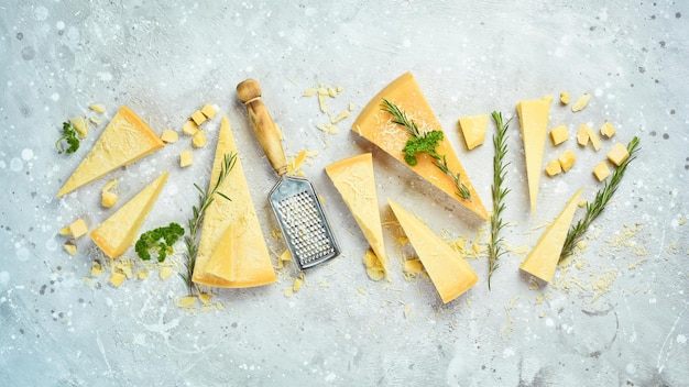 Fondo de queso. Trozos triangulares de queso duro sobre un fondo de piedra. Parmesano. Espacio libre para texto.