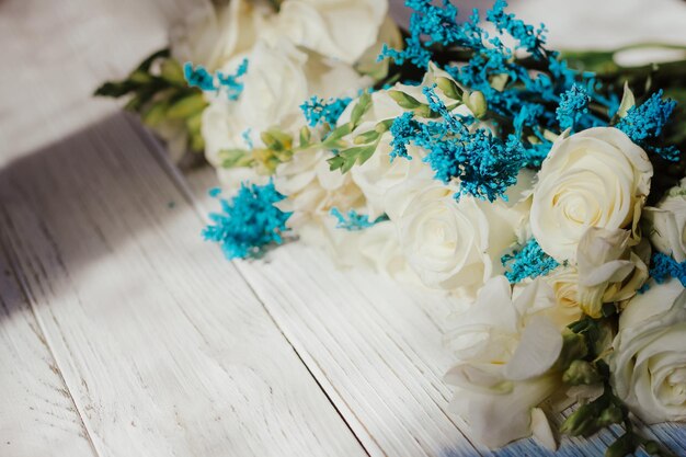 Fondo con un ramo de flores en tablas de madera blancas