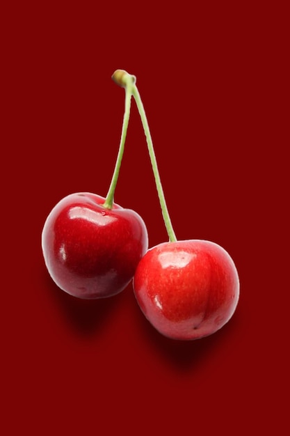 Un fondo rojo con dos cerezas