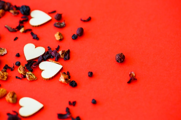 Fondo rojo de San Valentín con corazones de madera y la palabra amor. Lugar para inscripciones, publicidad. Enfoque selectivo